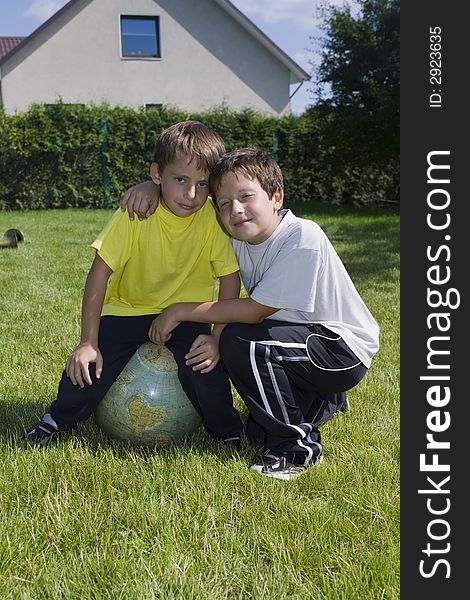 Brothers and globe on lawn in courtyard of the building