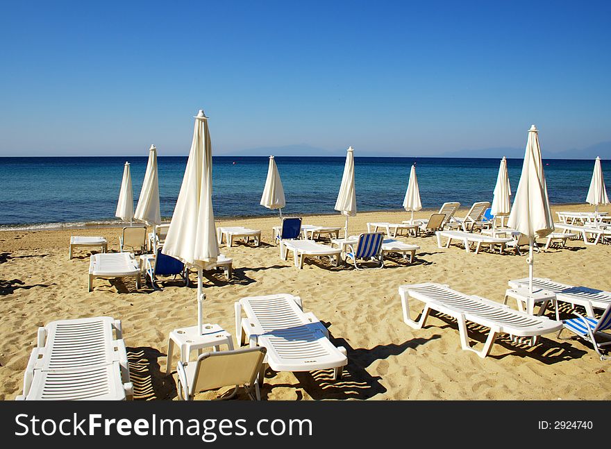 Sandy beach with white umbrellas and chairs