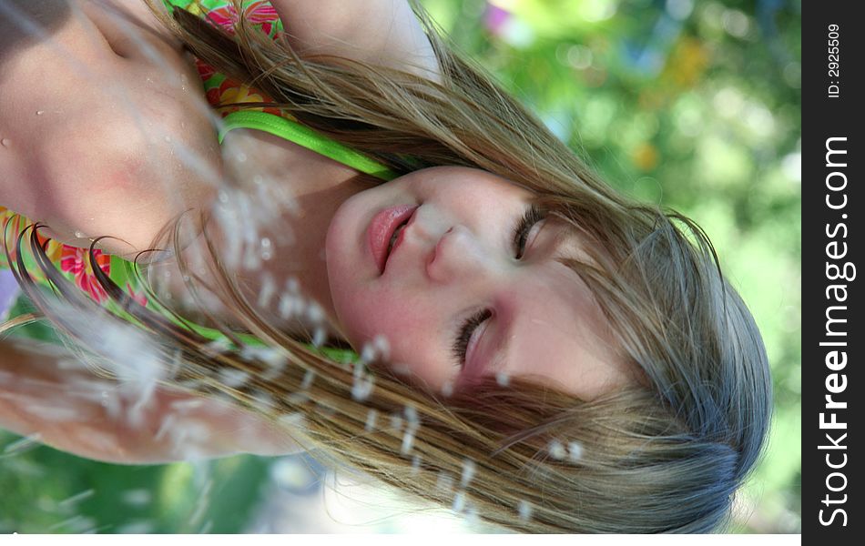 A little girl splashing in the sprinkler. A little girl splashing in the sprinkler