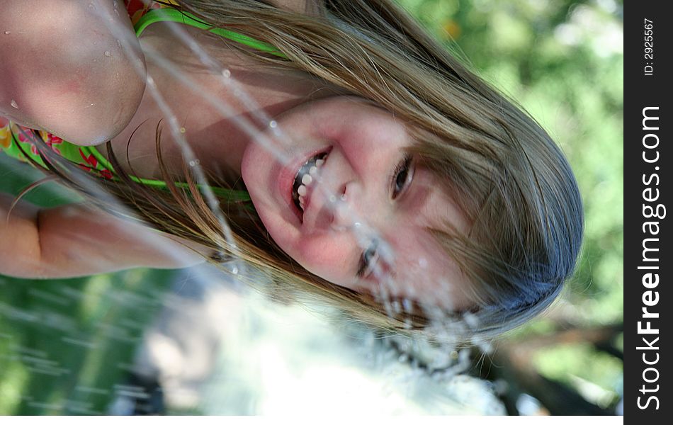A little girl splashing in the sprinkler. A little girl splashing in the sprinkler