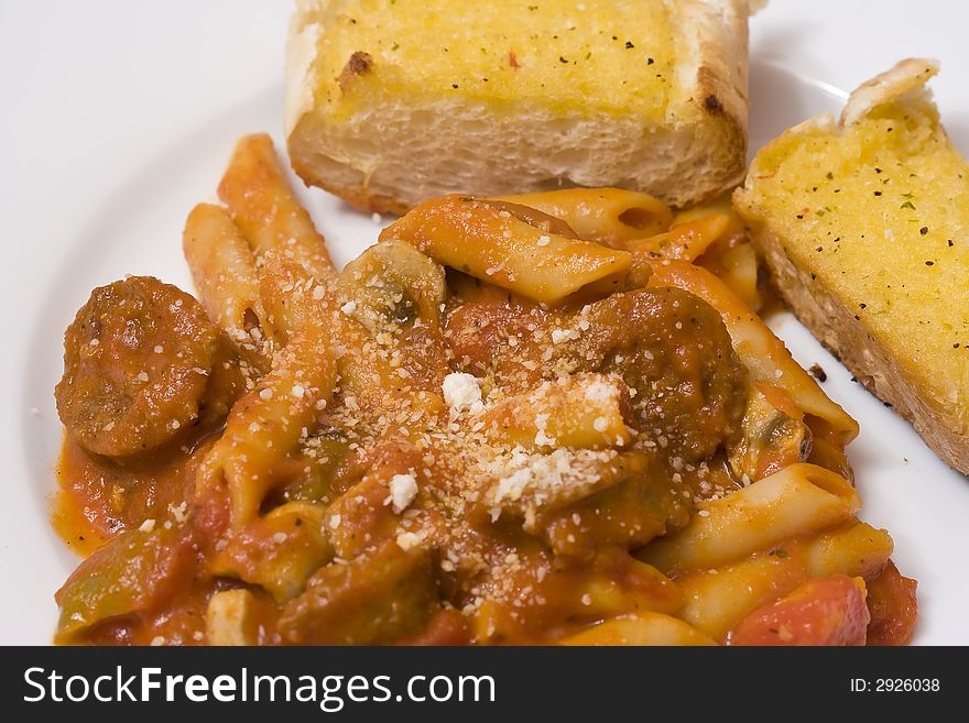 Serving of penne spaghetti white dishes nice reddish colors. Serving of penne spaghetti white dishes nice reddish colors