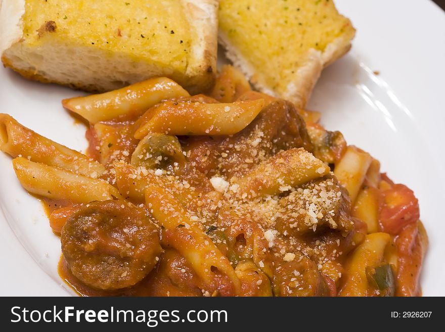 Serving of penne spaghetti white dishes nice reddish colors. Serving of penne spaghetti white dishes nice reddish colors