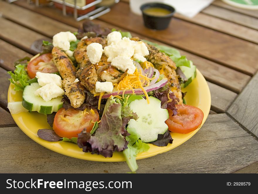 Green salad with grilled chicken on top