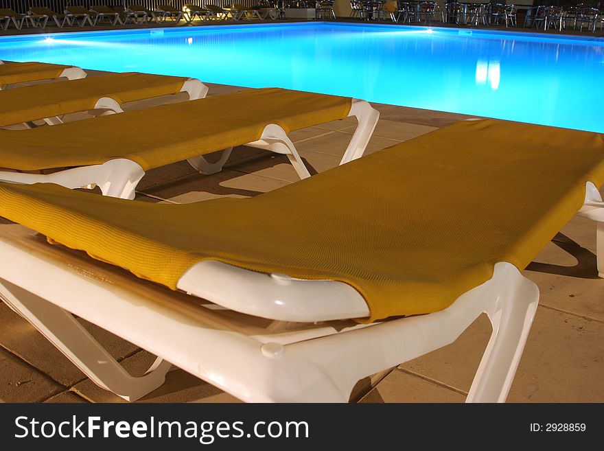 View of sunbeds and pool at night