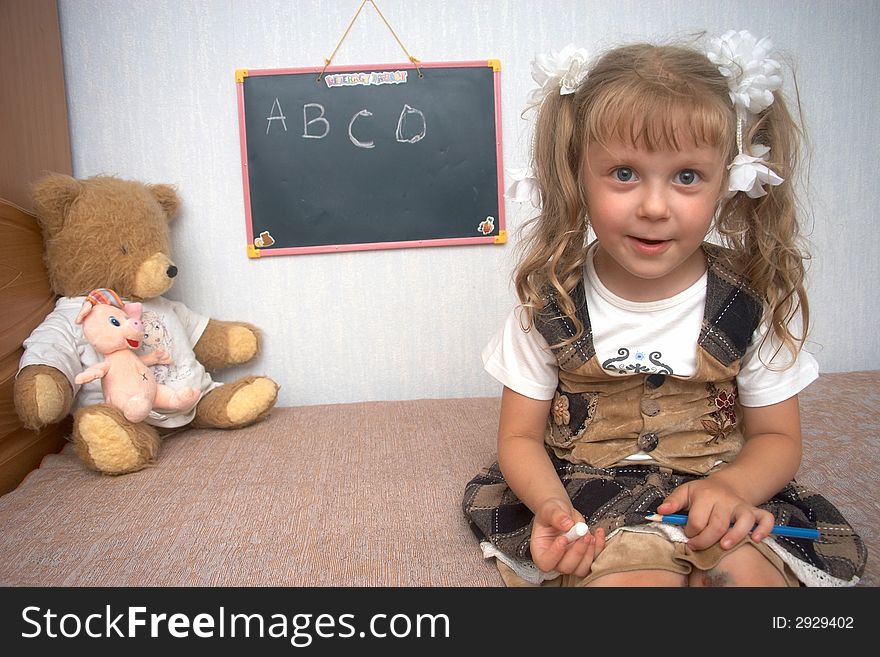 A girl with toys and school alackboard