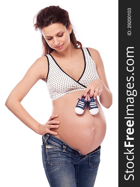 Pregnant woman caring small shoes.