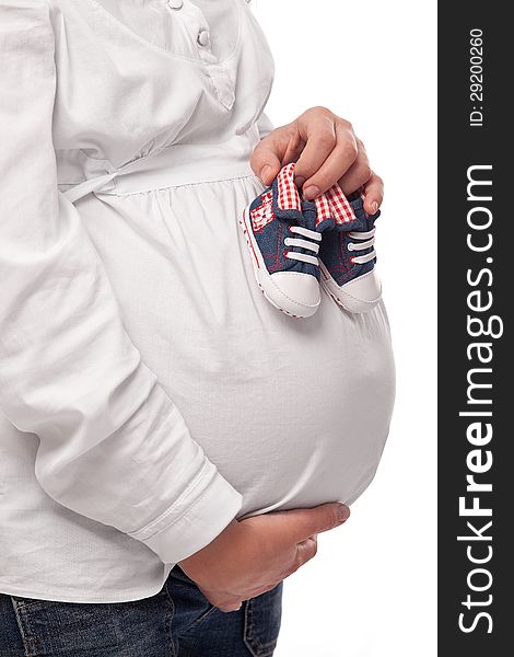 Pregnant woman keeping baby-shoes