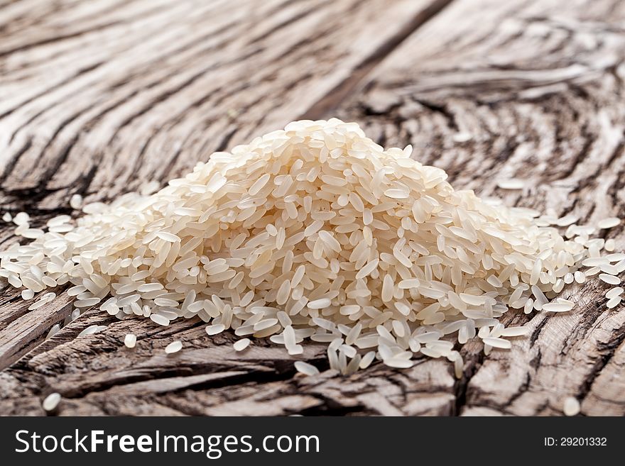 Handful of rice on a wooden table.