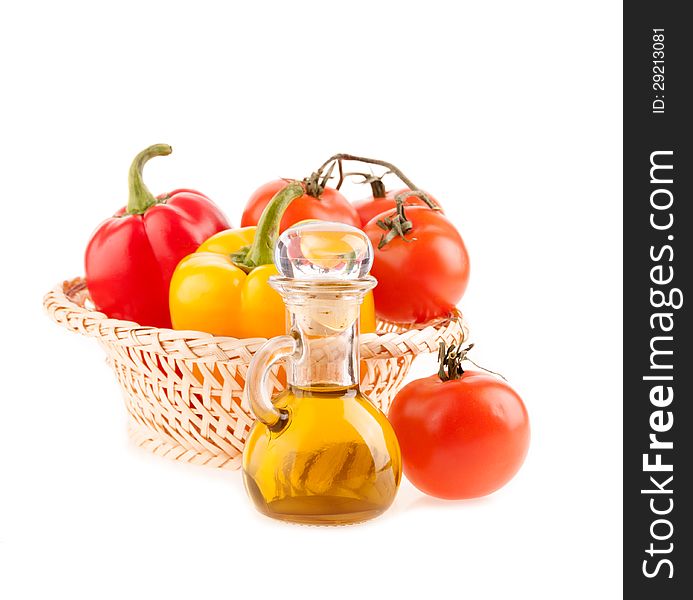 Bottle with olive oil on the background of the wattled dish with tomatoes and pepper on a white background