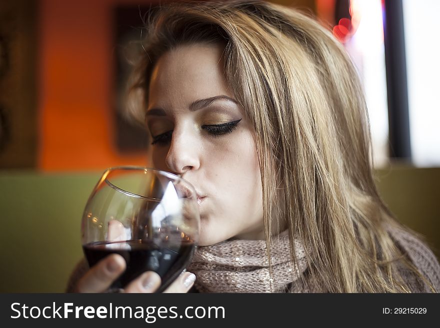 Portrait of a young woman with closed eyes drinking a glass of red wine. Portrait of a young woman with closed eyes drinking a glass of red wine.