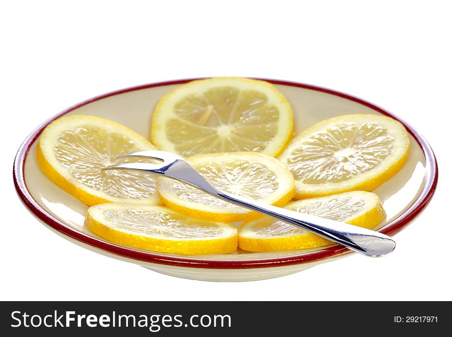 Fork on a plate with lemon isolated on white background