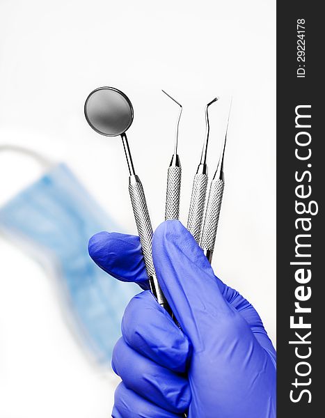 Gloved dentist hand holding dental instruments