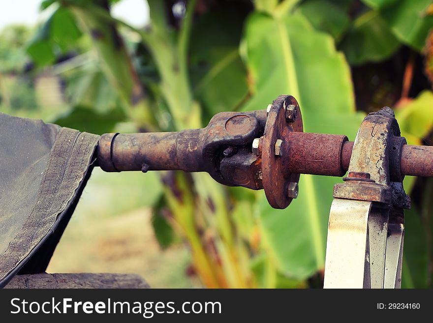 The old and rusty shaft of the water pump in the country part of Thailand