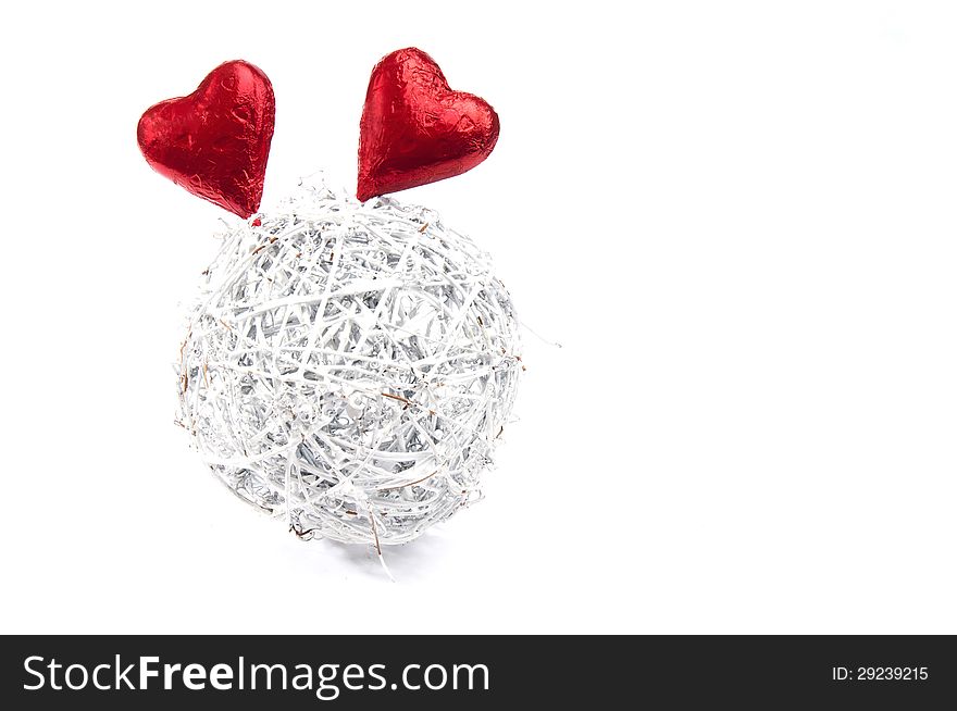 Two red hearts sticking out of a white wicker ball on an isolated white background. Two red hearts sticking out of a white wicker ball on an isolated white background