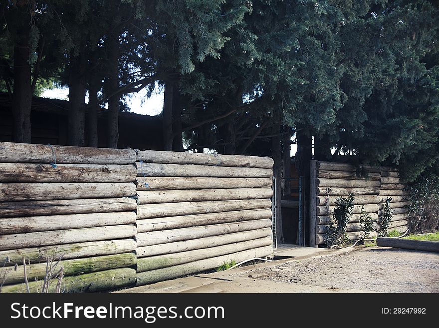 A wooden fence with an entrance to a park in the forest