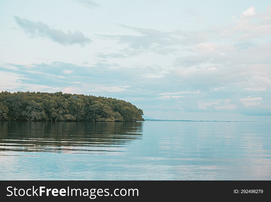 Beautiful View Of Clouds And Trees Reflecting On The Water. Beautiful Background