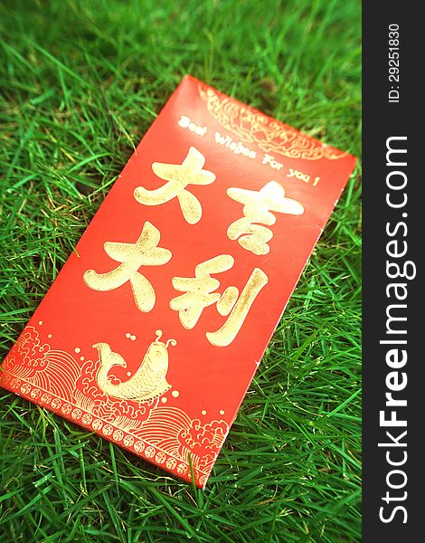 Red paper containing money on green grass