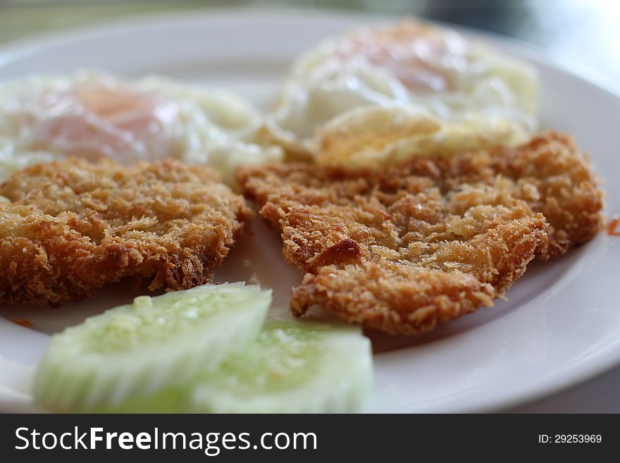 Fried fish served with eggs and cucumber. Fried fish served with eggs and cucumber