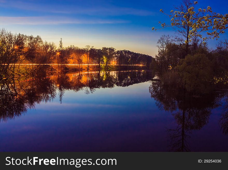 Reflection of trees in the river at evening