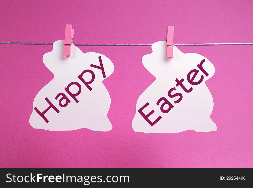 Two bunny rabbit shape Easter cards hanging from pegs on a line, with Happy Easter message in pink.