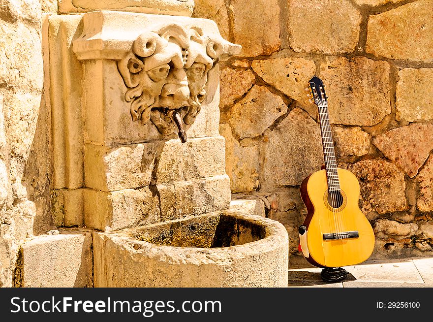 Gitar is standing near fountan at a sunny day in Spain. Gitar is standing near fountan at a sunny day in Spain