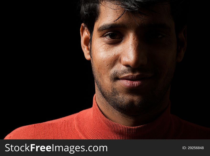 Portrait Of Young Indian  Man Smiling Over Dark