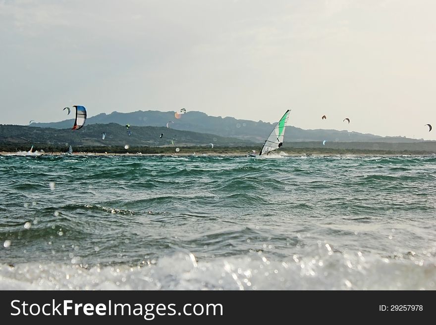 Backlight photo Day of sun wind surfer on spot and in the foreground kite surfing on the beautiful background. Backlight photo Day of sun wind surfer on spot and in the foreground kite surfing on the beautiful background.