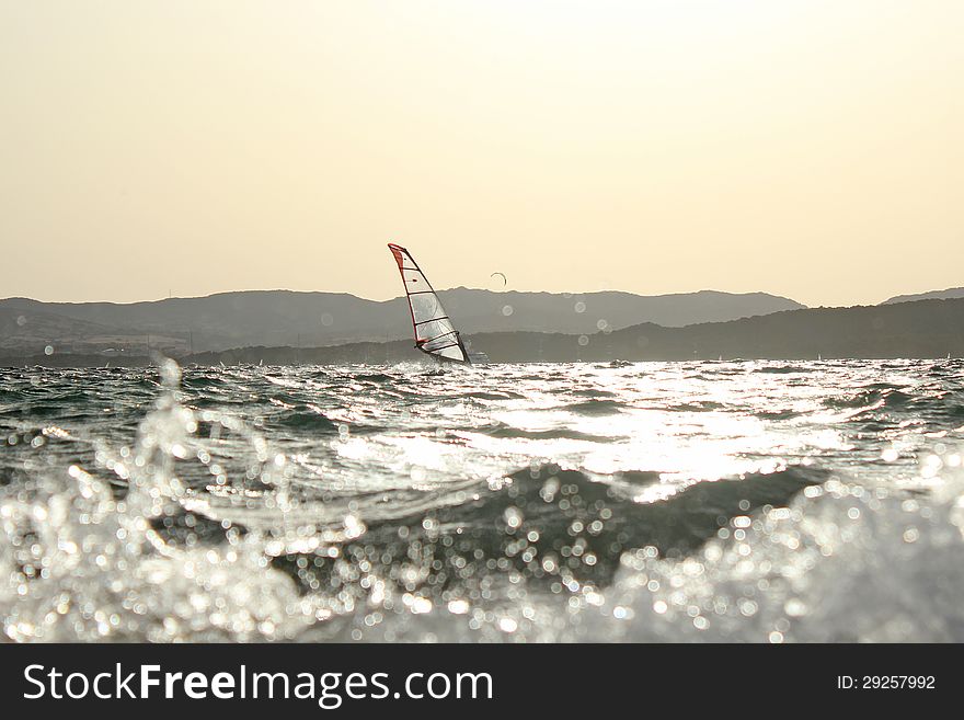 Backlight photo Day of sun wind surfer on spot and in the foreground kite surfing on the beautiful background. Backlight photo Day of sun wind surfer on spot and in the foreground kite surfing on the beautiful background.