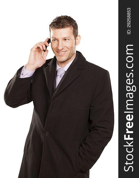 Smiling man in a coat telephones on white background