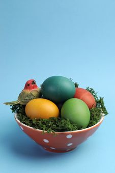 Easter Still Life With Rainbow Color Eggs In Orange Polka Dot Bowl Against A Blue Background. Easter Still Life With Rainbow Color Eggs In Orange Polka Dot Bowl Against A Blue Background.