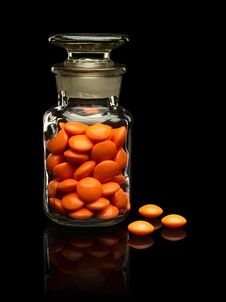 Glass Vial With A Glass Cover And Pills Of Orange Colors. Stock Images Glass Vial With A Glass Cover And Pills Of Orange Colors. Stock Images