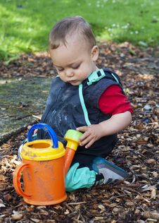 Child Playing With Watering Can Royalty Free Stock Photos