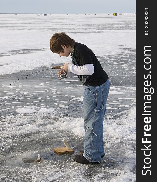 Boy ice fishing on a Minnesota lake