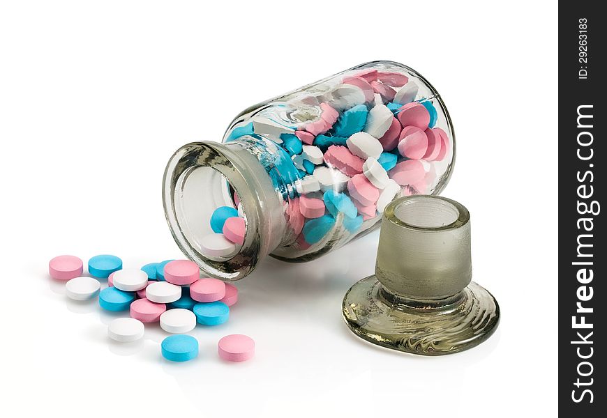 Glass vial with a glass stopper and group a pill on a white background. Glass vial with a glass stopper and group a pill on a white background