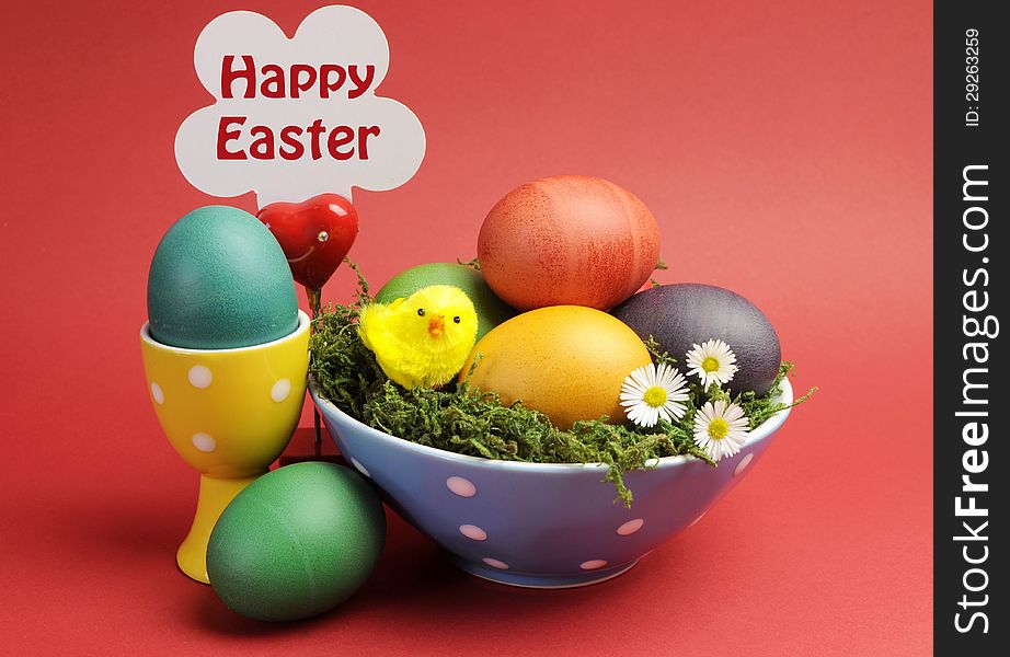 Bright and cheerful Happy Easter still life with rainbow color eggs in orange polka dot bowl against a red background. Bright and cheerful Happy Easter still life with rainbow color eggs in orange polka dot bowl against a red background.