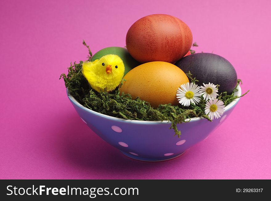 Bright and cheerful Happy Easter still life with rainbow color eggs in orange polka dot bowl against a pink background. Bright and cheerful Happy Easter still life with rainbow color eggs in orange polka dot bowl against a pink background.