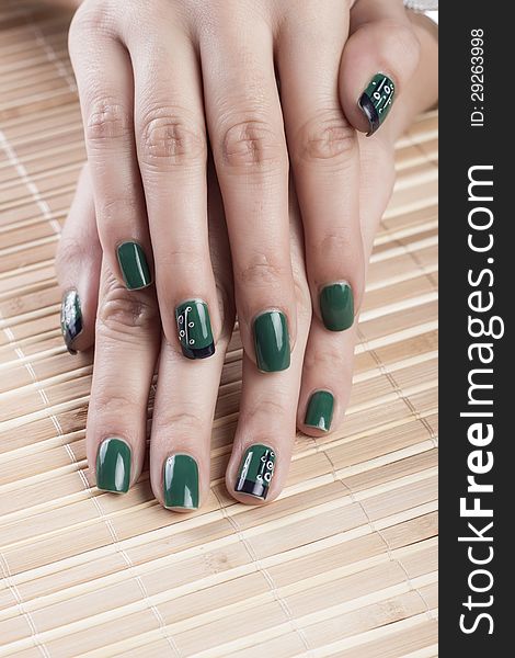Green nail polish on female fingers.