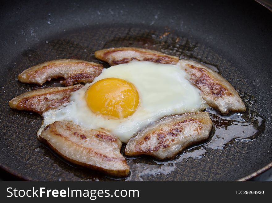 Bacon And Eggs Cooking In A Skillet