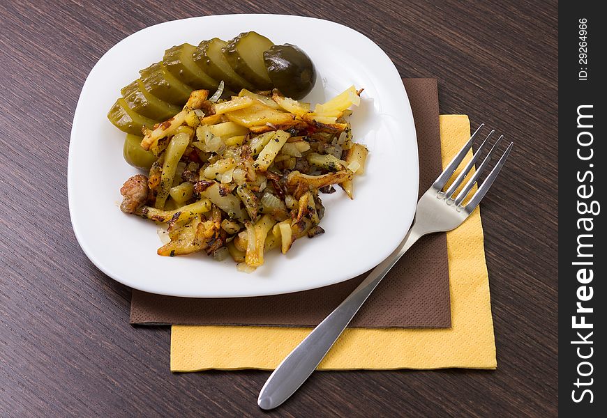 Fried potato with cucumber on white dish