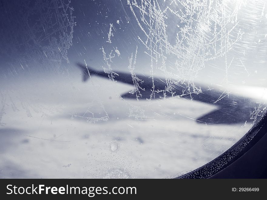 Frosty Patterns At A Plane Window Over Clouds