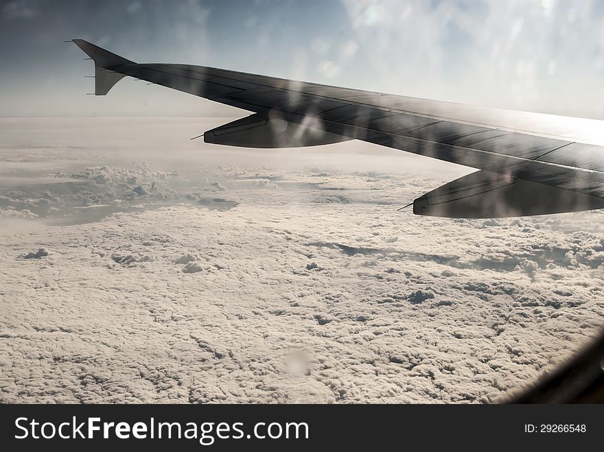 Frosty patterns at a plane window at height over clouds. Frosty patterns at a plane window at height over clouds