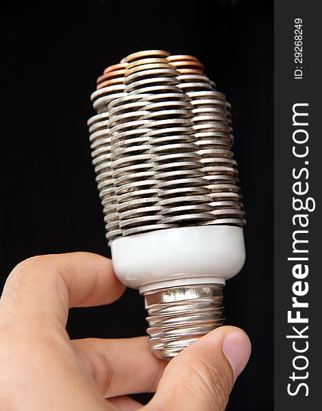 Hand holding coin light bulb concept