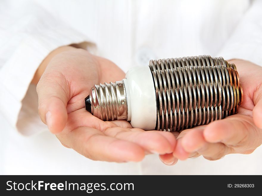 Hand holding coin light bulb concept