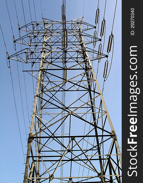 Steel Tower Holding Electrical Cables Against Blue Sky. Steel Tower Holding Electrical Cables Against Blue Sky