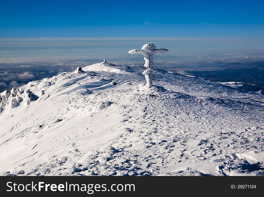 Winter top of the mountain with a cross