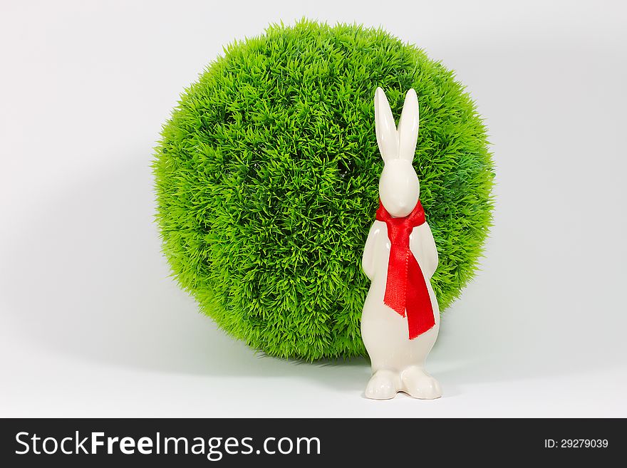 The Easter Bunny is waiting before a Green Bush. The Easter Bunny is waiting before a Green Bush