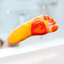 Little Girl With Feet Painted Colors. Royalty Free Stock Photos