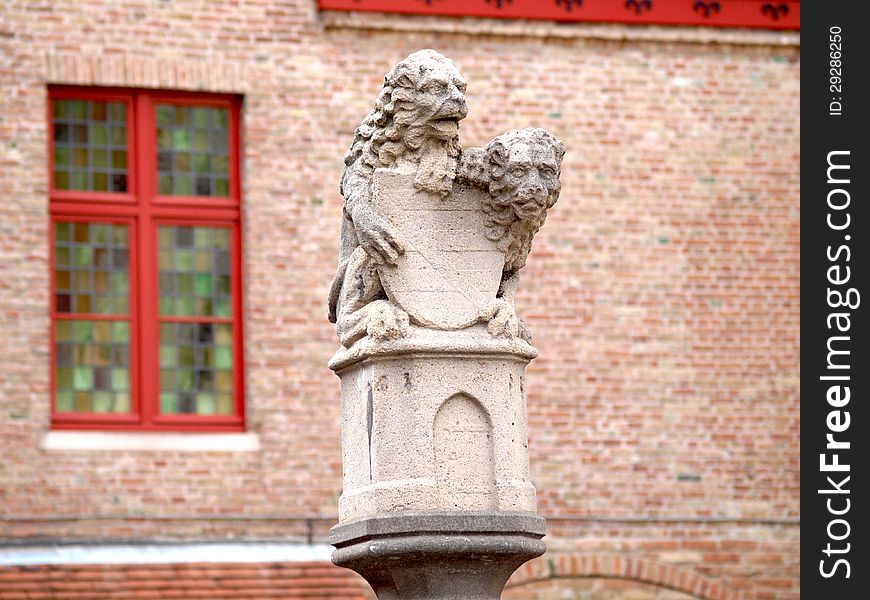 Statue of two lions guarding the shield, on way to the Market Square, Bruges, Belgium. Statue of two lions guarding the shield, on way to the Market Square, Bruges, Belgium