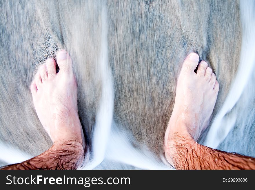 Feet of the man in the sea close-up. Feet of the man in the sea close-up