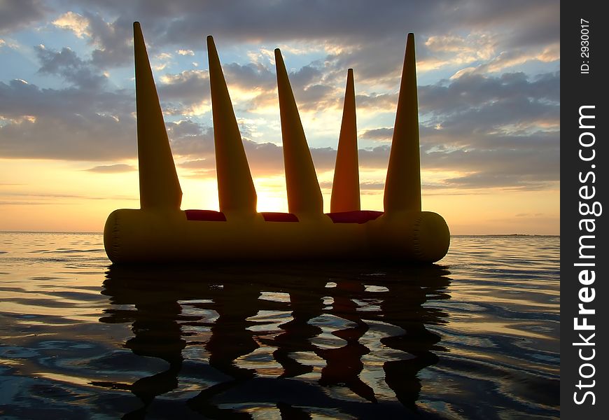 Greater bright inflatable toy on water on a sunset 2